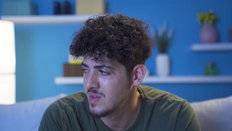 Close-up-of-depressed-young-man-at-home-at-night.