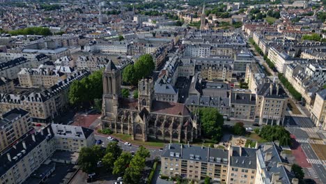 high altitude panning aerial movement about the church of saint jean as known as the leaning church, caen, france