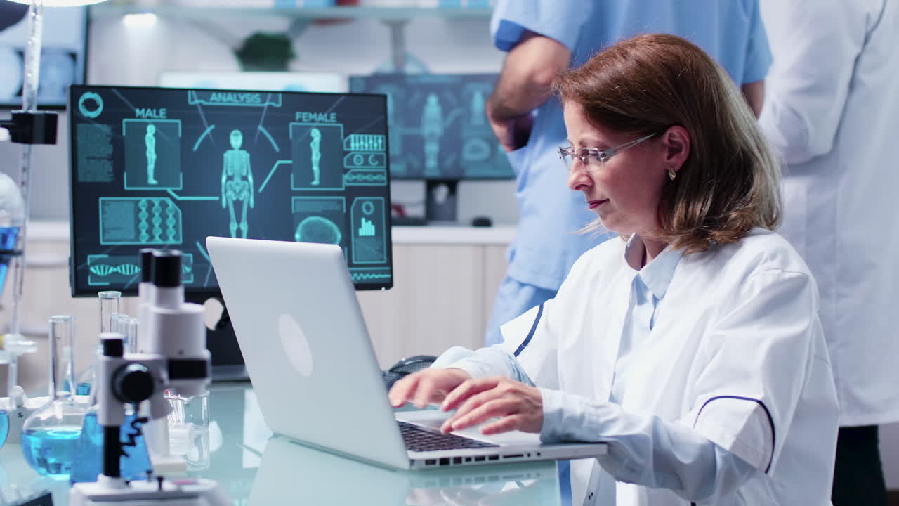 Scientists working in a lab with laptops and medical equipment