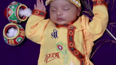 newborn baby boy in krishna dressed with props from unique perspective in different expression