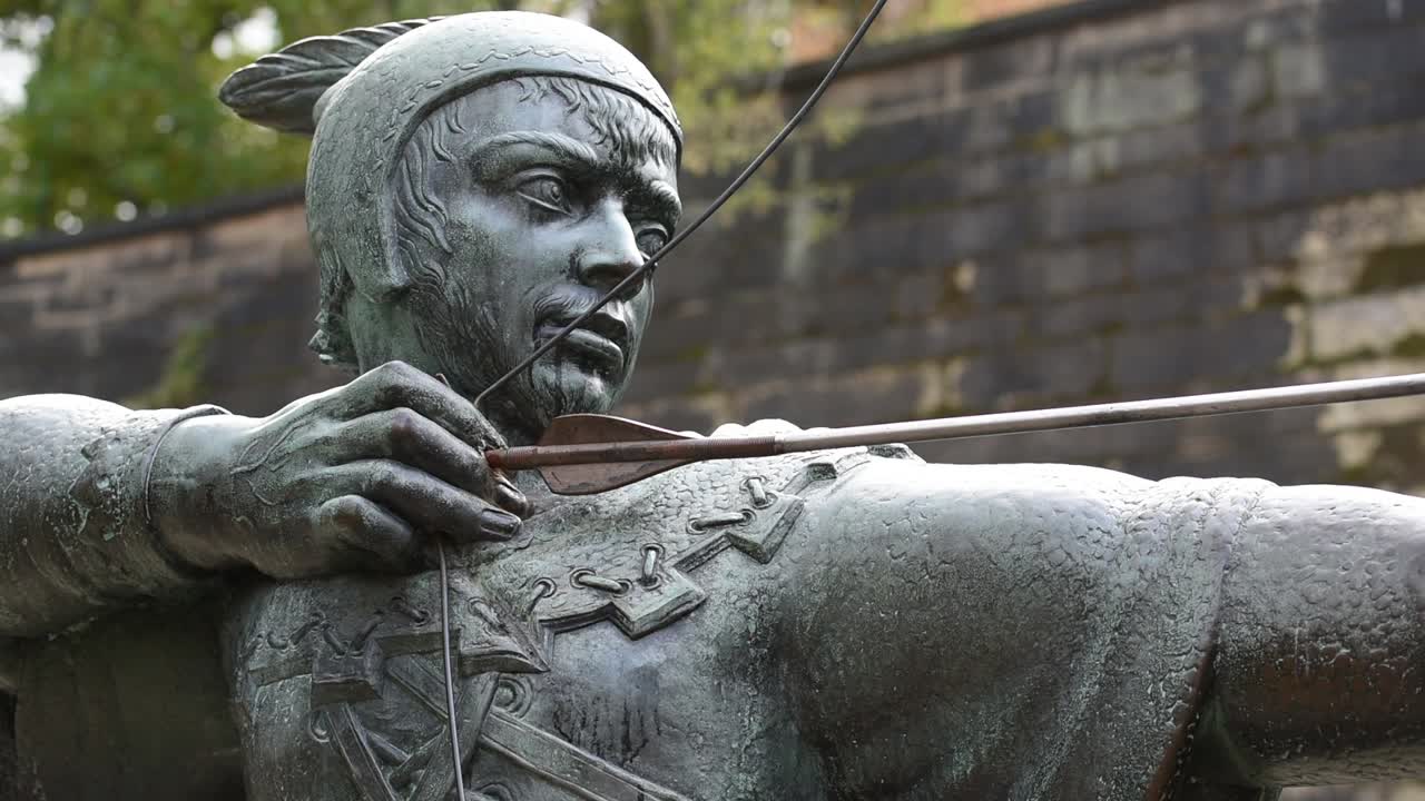 The Robin Hood statue stands proudly on Castle Road in Nottingham, England, aiming his arrow toward the historic gatehouse of Nottingham Castle