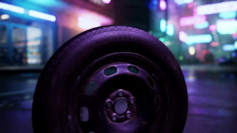 a close-up shot of a spare tire on a wet street at night with neon lights in the background