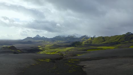 A-drone-video-from-the-Highlands-of-South-Iceland-showing-black-sands,-green-moss-and-snow-in-the-mountains