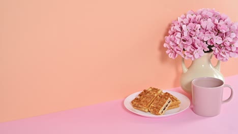 dessert waffles with cup of coffee with spring flowers in vase. stop motion