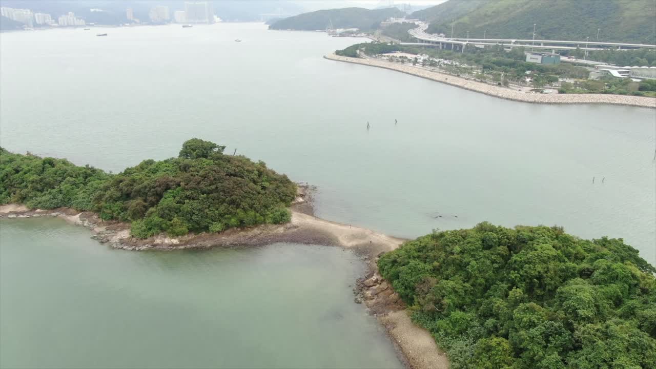 bahía de hong kong, con una franja de arena que conecta pequeñas islas naturales, vista aérea
