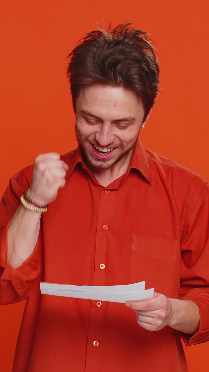 Happy caucasian man open envelope take out letter reads bank loan approve great news award win