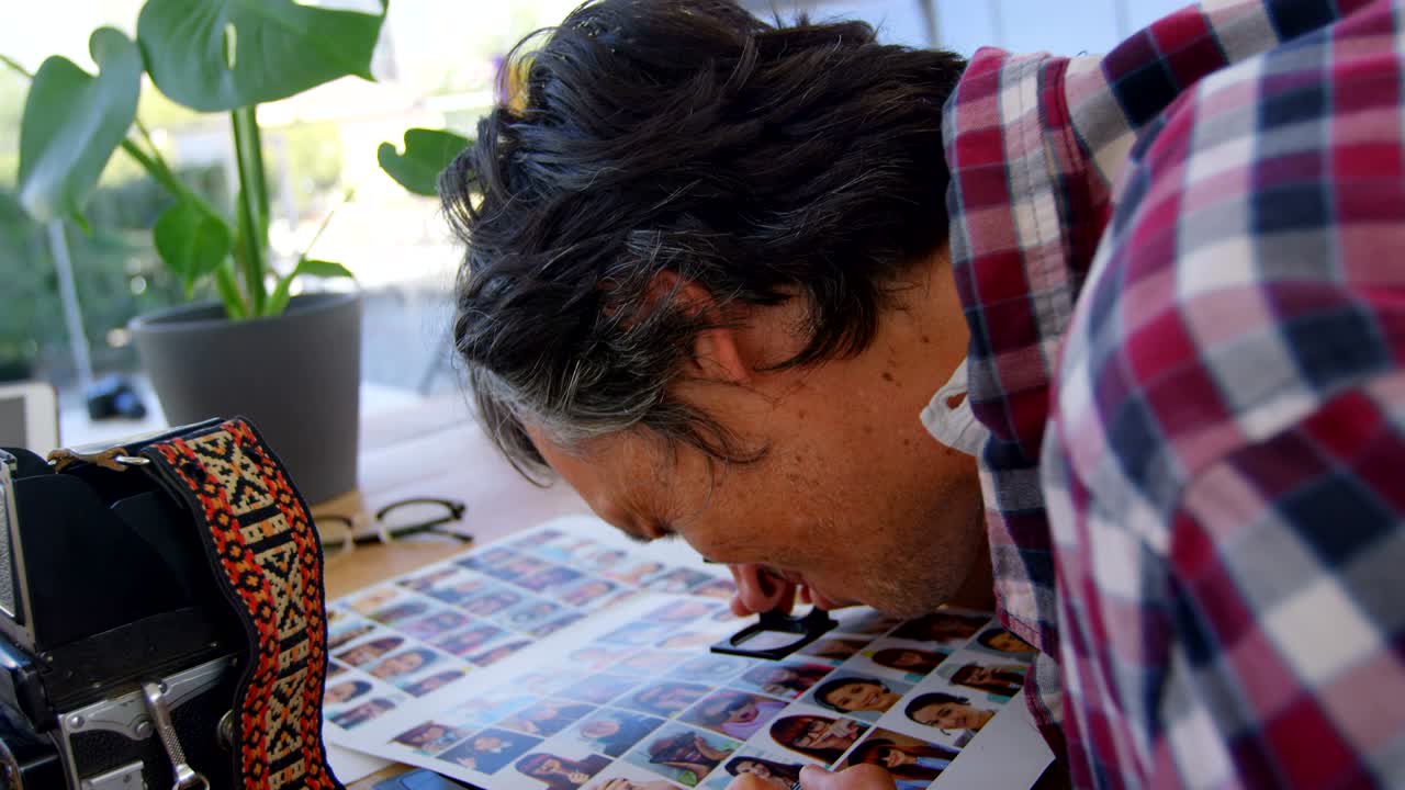 fotógrafo masculino comprobando fotos con lupa 4k