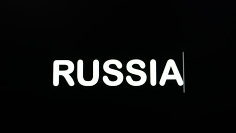 близкий взгляд на россию, записываемую на экране монитора компьютера с мигающим курсором на черном фоне.