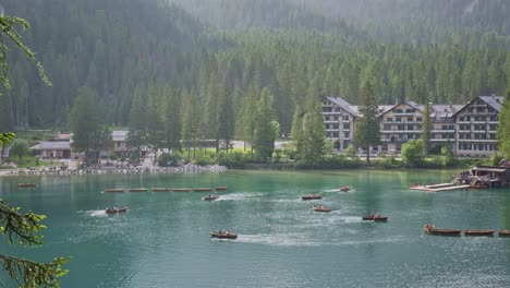 tourists enjoy rowing boat activity on dolomites alpine lake braies