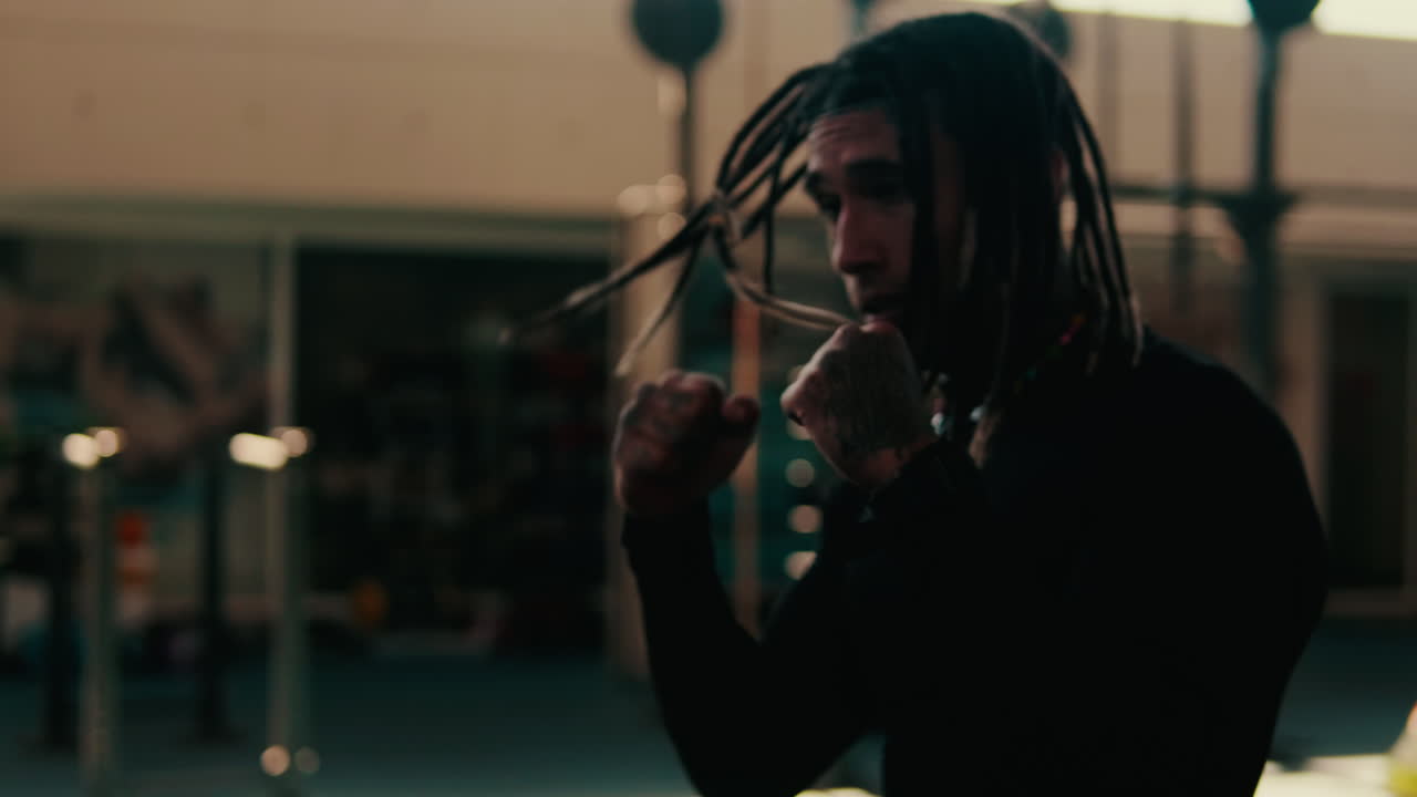 Young Man with Dreadlocks Practicing Boxing in a Gym