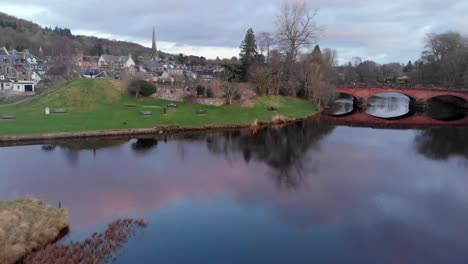 aerial footage - flying over a river and a small town in scottish highlands