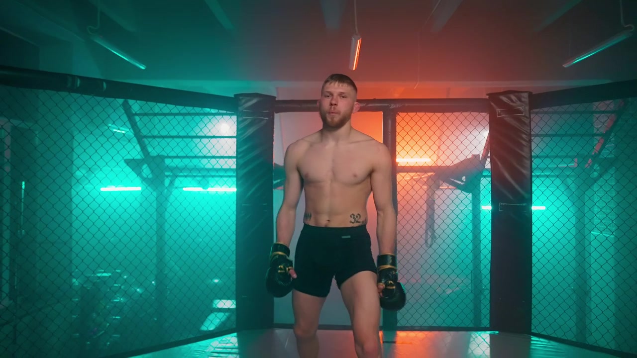Lottatore determinato che entra nella gabbia MMA con guantoni da boxe