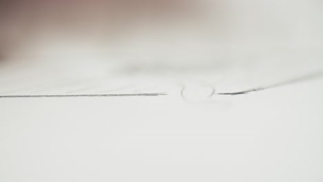 lápiz dibujando una línea delgada en papel blanco, disparo macro
