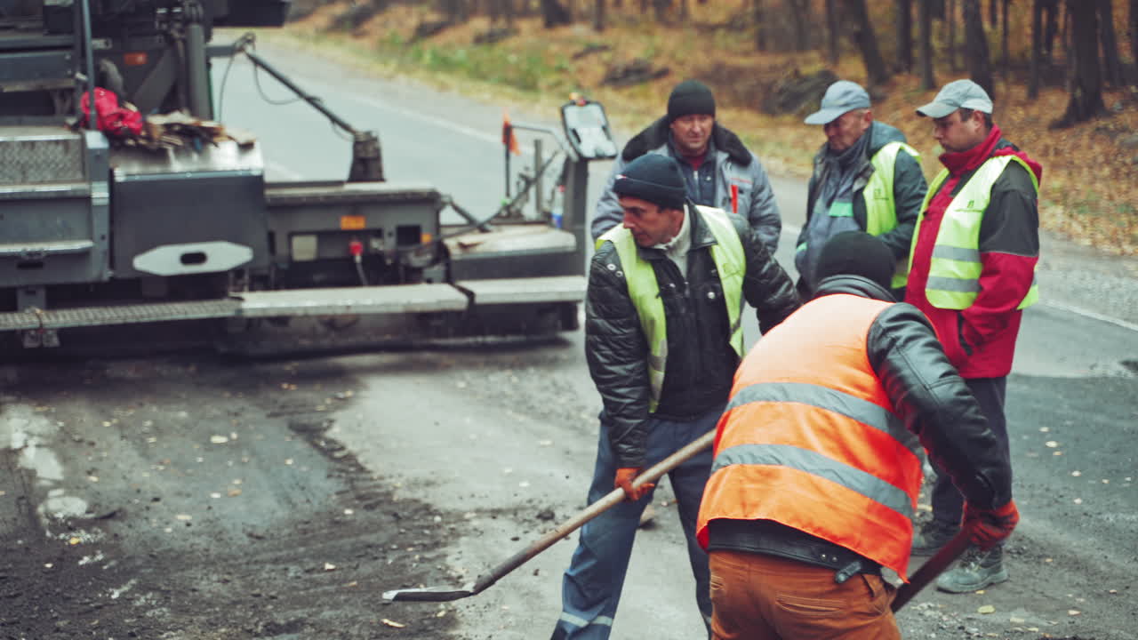 Workers on road construction. Roller and workers on asphalting and repair of highway