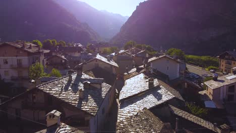 pueblo de los alpes italianos en un día soleado, vista aérea de drones con movimiento hacia adelante