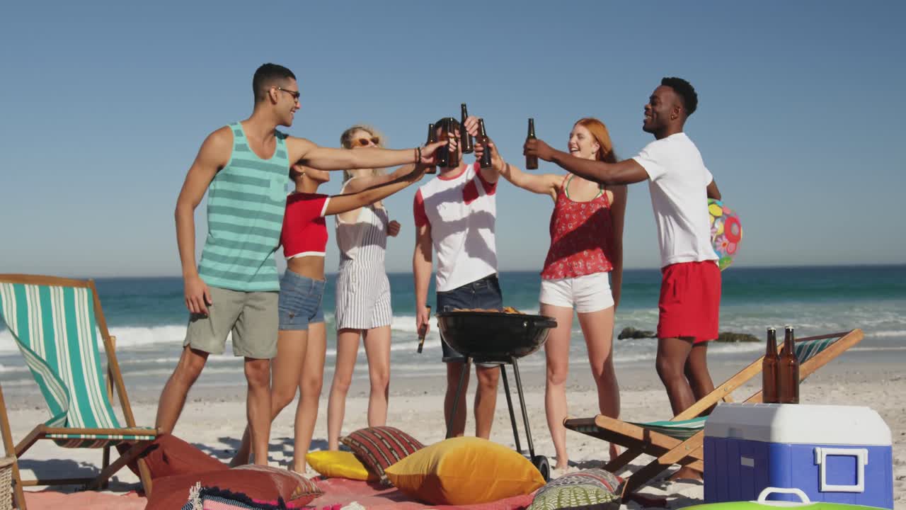 amigos adultos jóvenes teniendo una barbacoa en una playa 4k