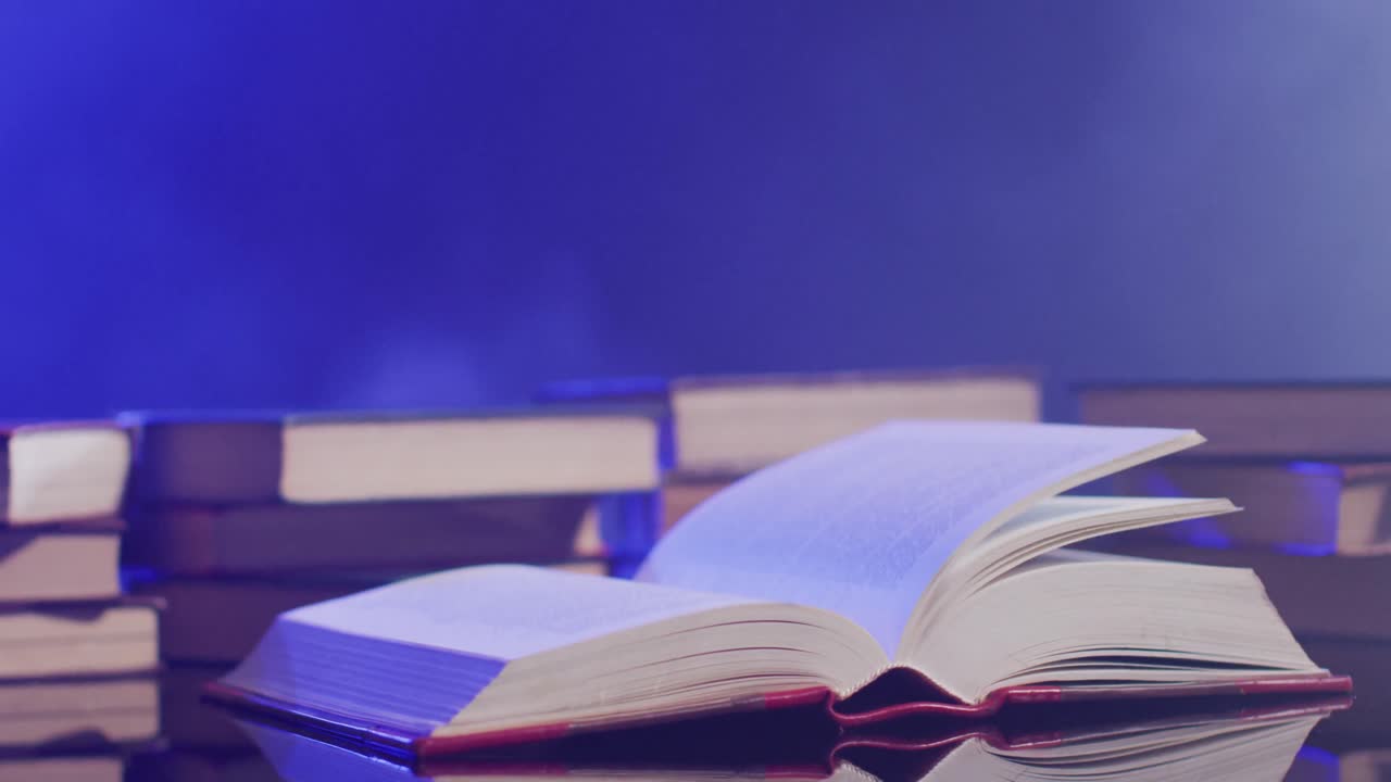 video de las páginas del libro moviéndose sobre los libros y el humo sobre un fondo negro