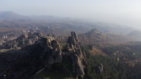 Pull-out-drone-shot-of-Belogradchik-Fortress,-an-ancient-fortress-on-the-slopes-of-the-Balkan-Mountains,a-cultural-and-historical-attraction,-and-one-of-the-best-preserved-strongholds-in-Bulgaria