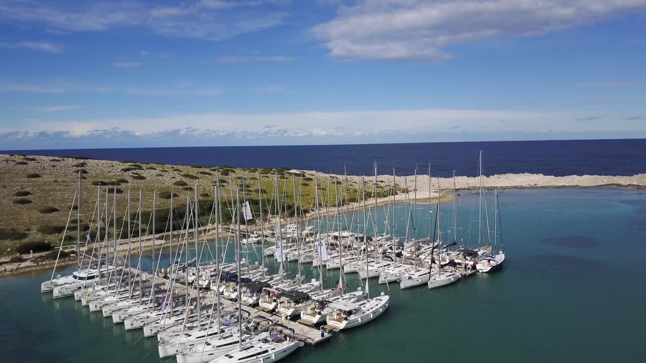 Sailboats moored in Marine Piskera, Kornati Islands in Croatia, Blue Sky in Background - Aerial Drone View