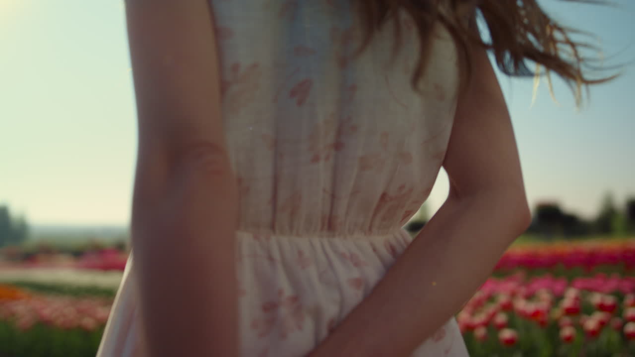 근접 촬영 튤립 필드에서 주위를 선회 하는 아름 다운 여자. 웃고 있는 긍정적인 소녀.