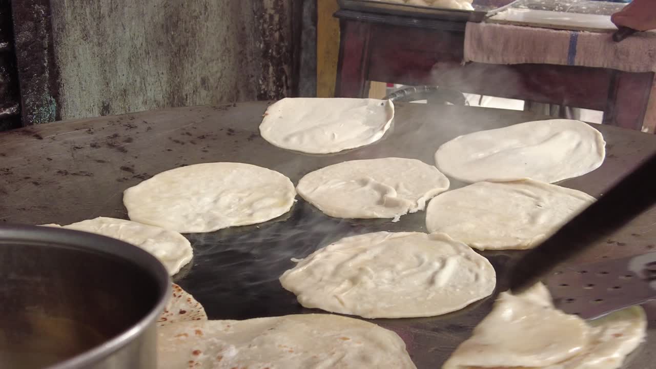 cocinando roti chapati en una sartén grande ,