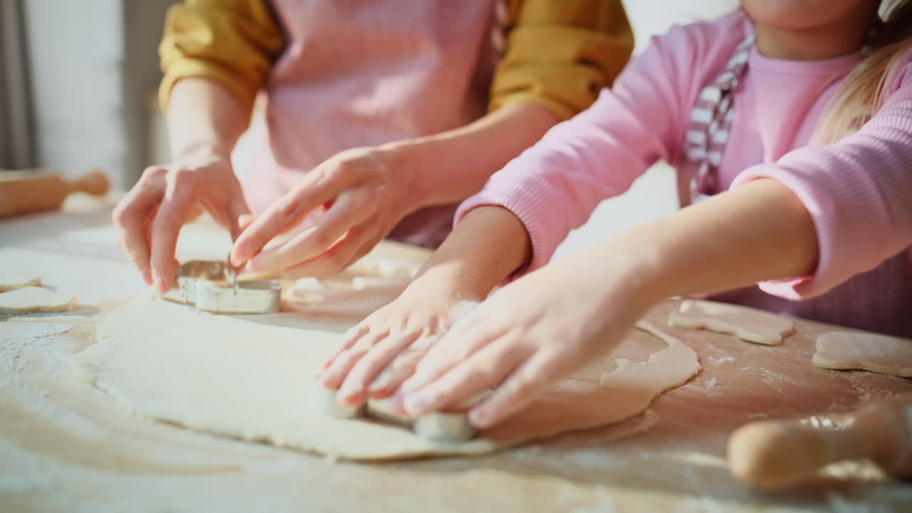 Focused family making cookies at table closeup. Mother daughter preparing food