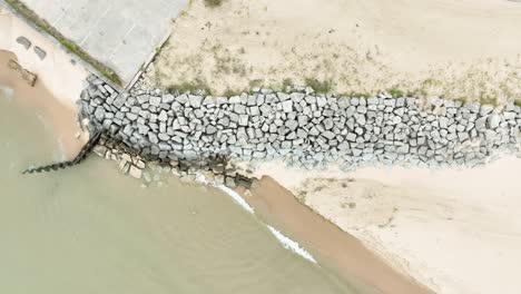 Tracking-through-the-frame,-showing-the-length-of-beach-reinforced-against-erosion