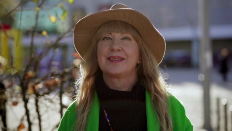 beautiful smiling mature lady in hat posing outdoor