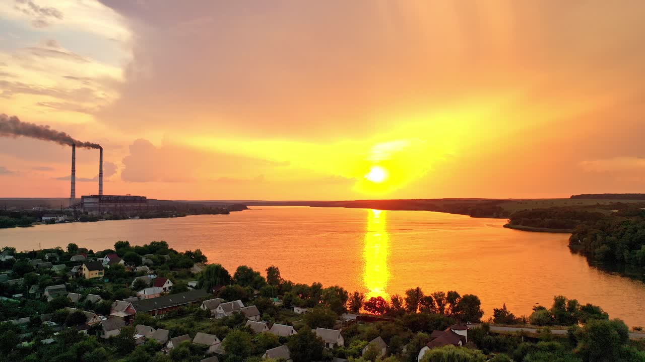 View from above the countryside near the river in the evening. Orange sun reflection in the water at beautiful rural background in summer at sunset. Camera moves right.