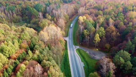 Luftaufnahme-Einer-Strecke,-Die-Auf-Der-Straße-In-Einem-Farbenfrohen-Herbstwald-Unterwegs-Ist