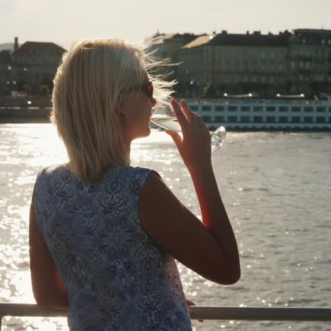 a woman with a glass of champagne sails on the boat