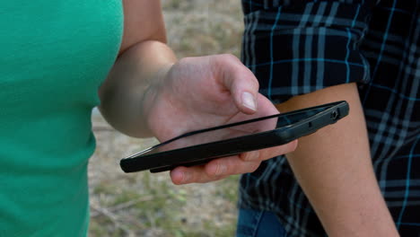 A female hand is looking at her phone and pushes one button.