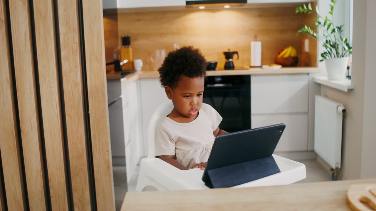 Toddler using tablet in a kitchen