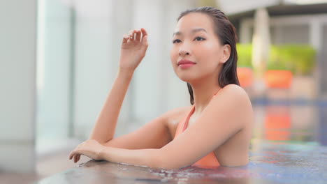 Wunderschöne-Asiatische-Frau,-Die-Im-Schwimmbad-Steht,-Mittlere-Schusszeitlupe