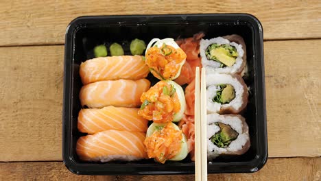 sushi rolls with salmon in plastic tray