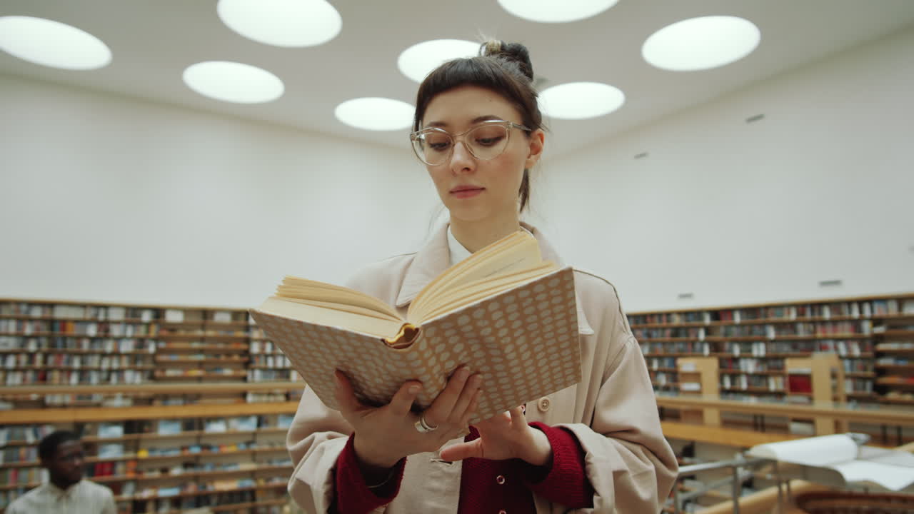 mujer joven leyendo un libro en la biblioteca