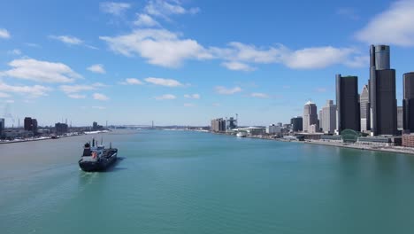 cargo ship sailing near majestic skyline of detroit, aerial drone view