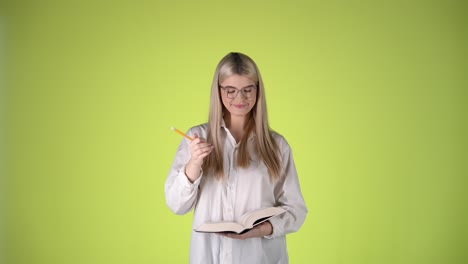 Amazed-Impressed-Intellectual-Young-Blonde-Woman,-Writing-Smart-Notes-and-Ideas,-Colorful-Studio-Shot