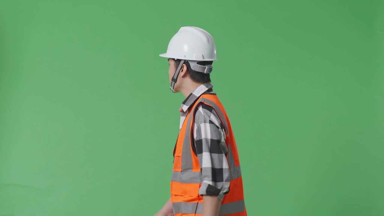 녹색 스크린 배경 스튜디오에서 는 동안 안전 헬을 입은 아시아 남성 엔지니어의 측면 시각