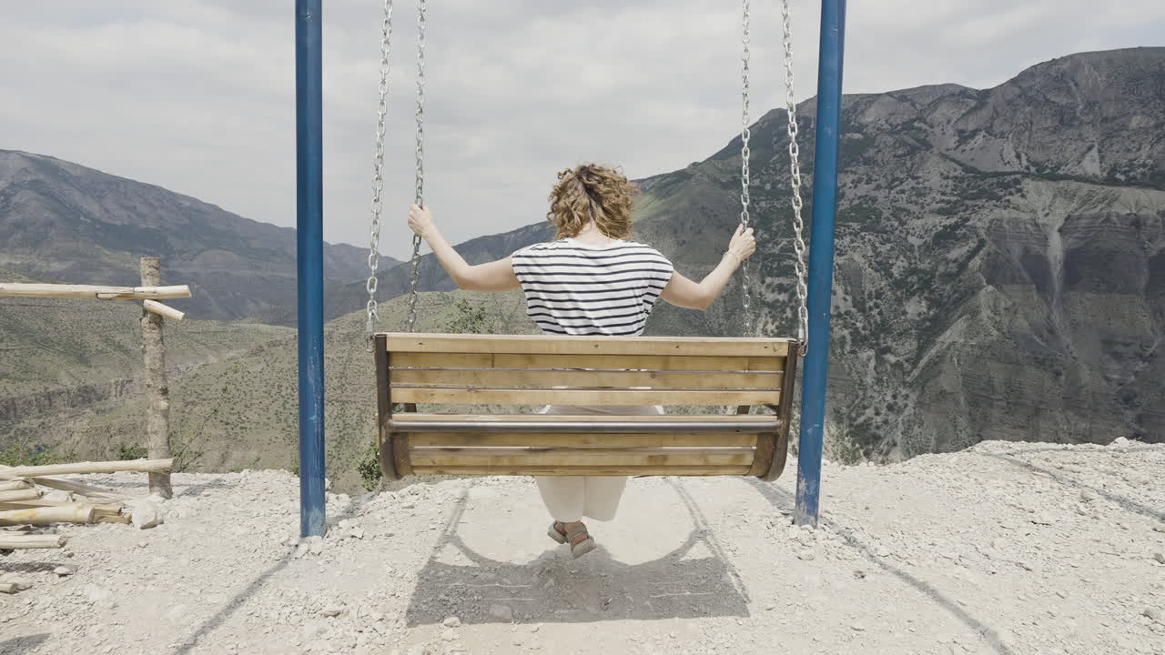 женщина, раскачивающаяся в горах.