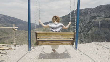 woman swinging in the mountains