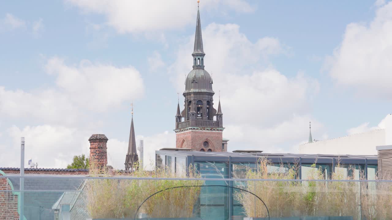 Copenhagen Cityscape: Rooftop View of Church Spire and Skyline