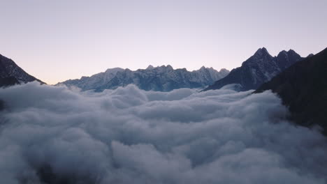 Un-Dron-Captura-El-Impresionante-Paisaje-De-Nepal-Con-Nubes-Debajo-De-La-Vasta-Cordillera-En-El-Campamento-Base-Del-Everest,-Visto-Desde-Tengboche.