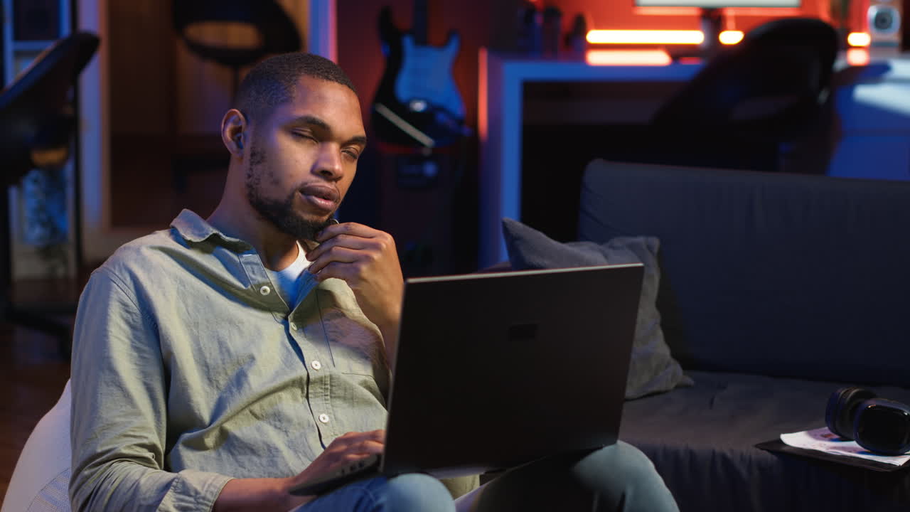 Vertical Video African american man working remotely from his modern loft on laptop