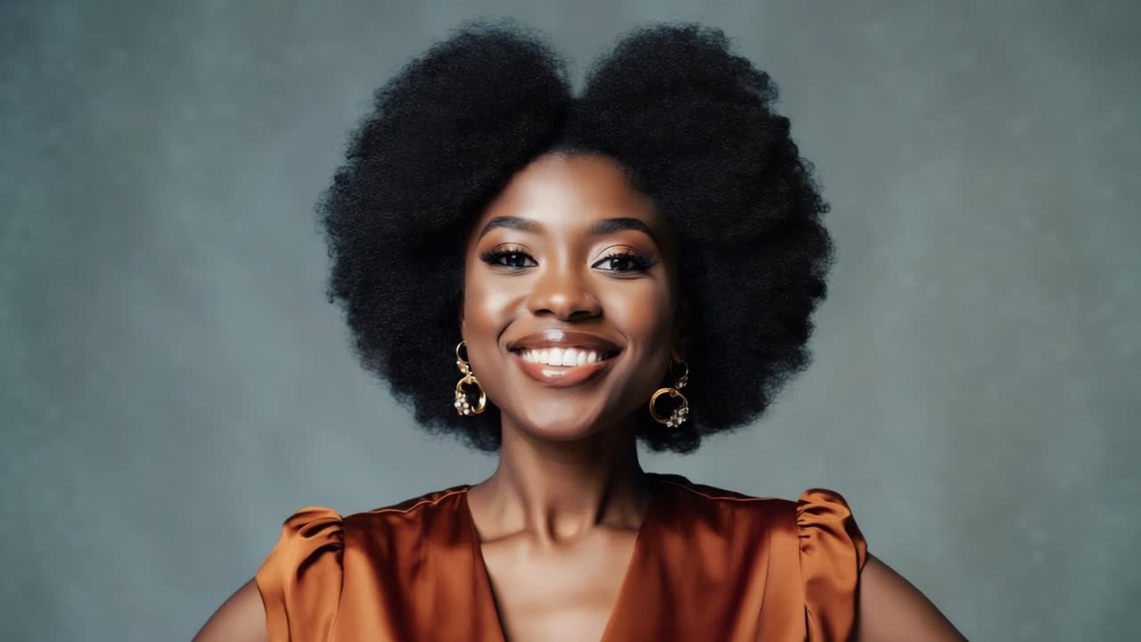 Professional portrait highlighting confident african american woman with voluminous curly hair, bright smile, donning vibrant orange dress and golden earrings against neutral gray backdrop