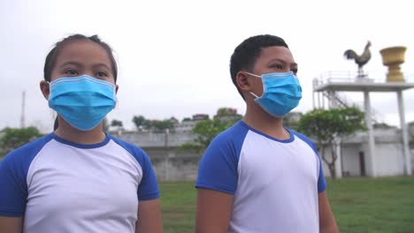 boy and girl wearing mask out door