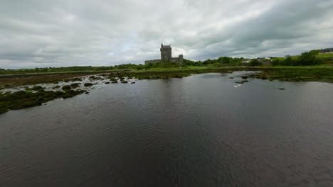 Drone-flying-fast-and-low-above-the-sea-towards-Dunguaire-castle-in-Ireland