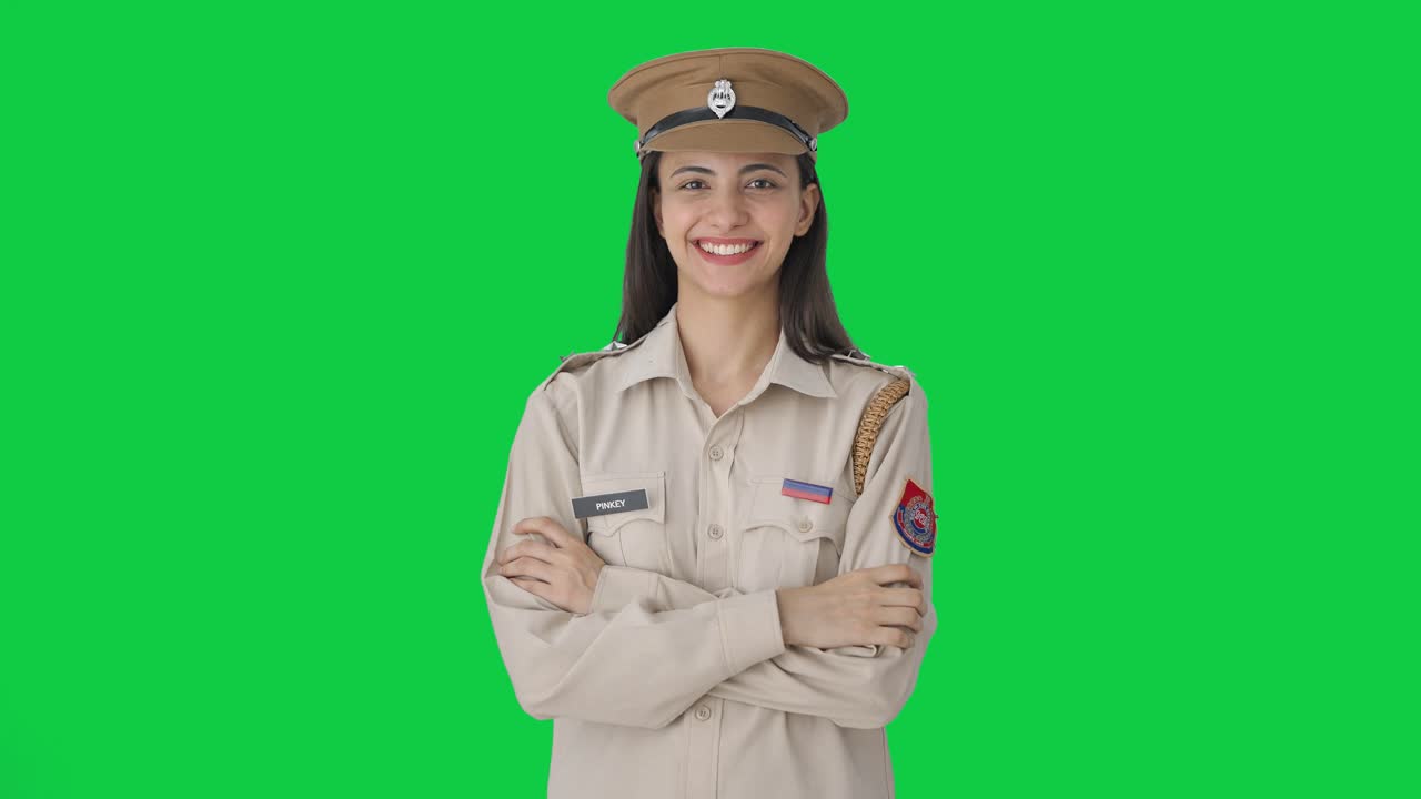Ritratto di felice poliziotta indiana su sfondo verde