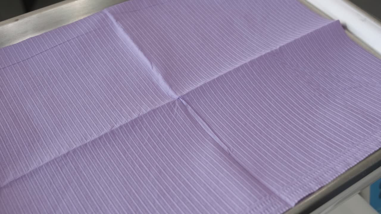 крупный план лотка для стоматологических инструментов: стоматолог кладет ротовое зеркало и пинцет