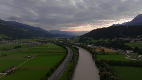 Aerial View of a River Valley with Highway and Mountains in the Background